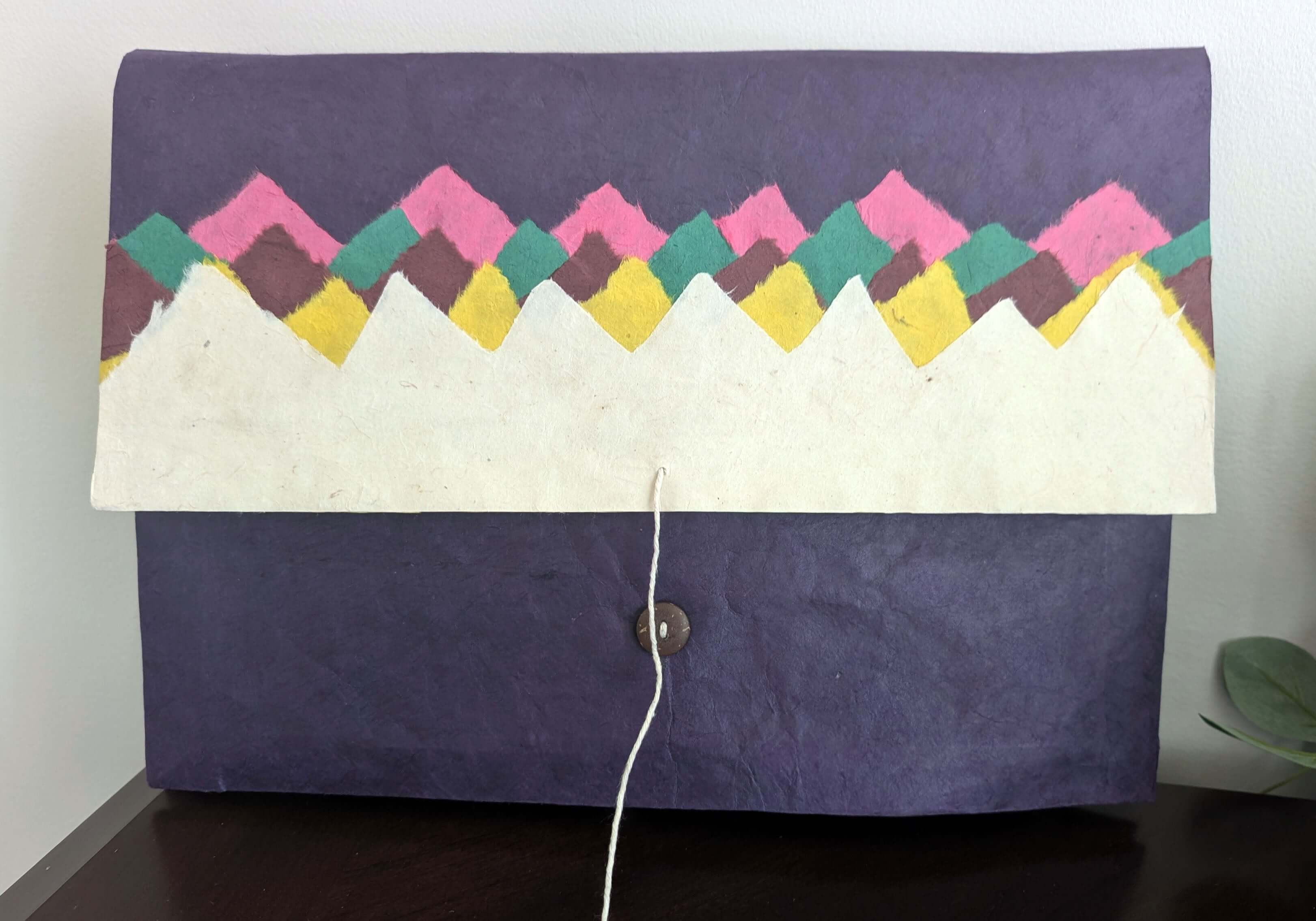 Front view of a handmade purple Lokta seminar file folder with colorful Himalayan mountain design flap