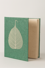 Open view of a handcrafted Lokta paper journal with a green Bodhi leaf cover, revealing 80 natural-textured pages inside.